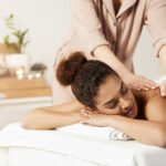 beautiful-african-woman-smiling-enjoying-massage-with-closed-eyes-spa-salon